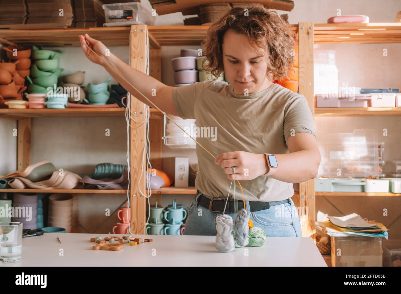 Donna che rende naturale sicuro accessori di legno sulla scrivania, eco stile. Cordoni. Giocattolo con decori di picchiettio a trinket. Lavoro artigianale di a. Foto Stock