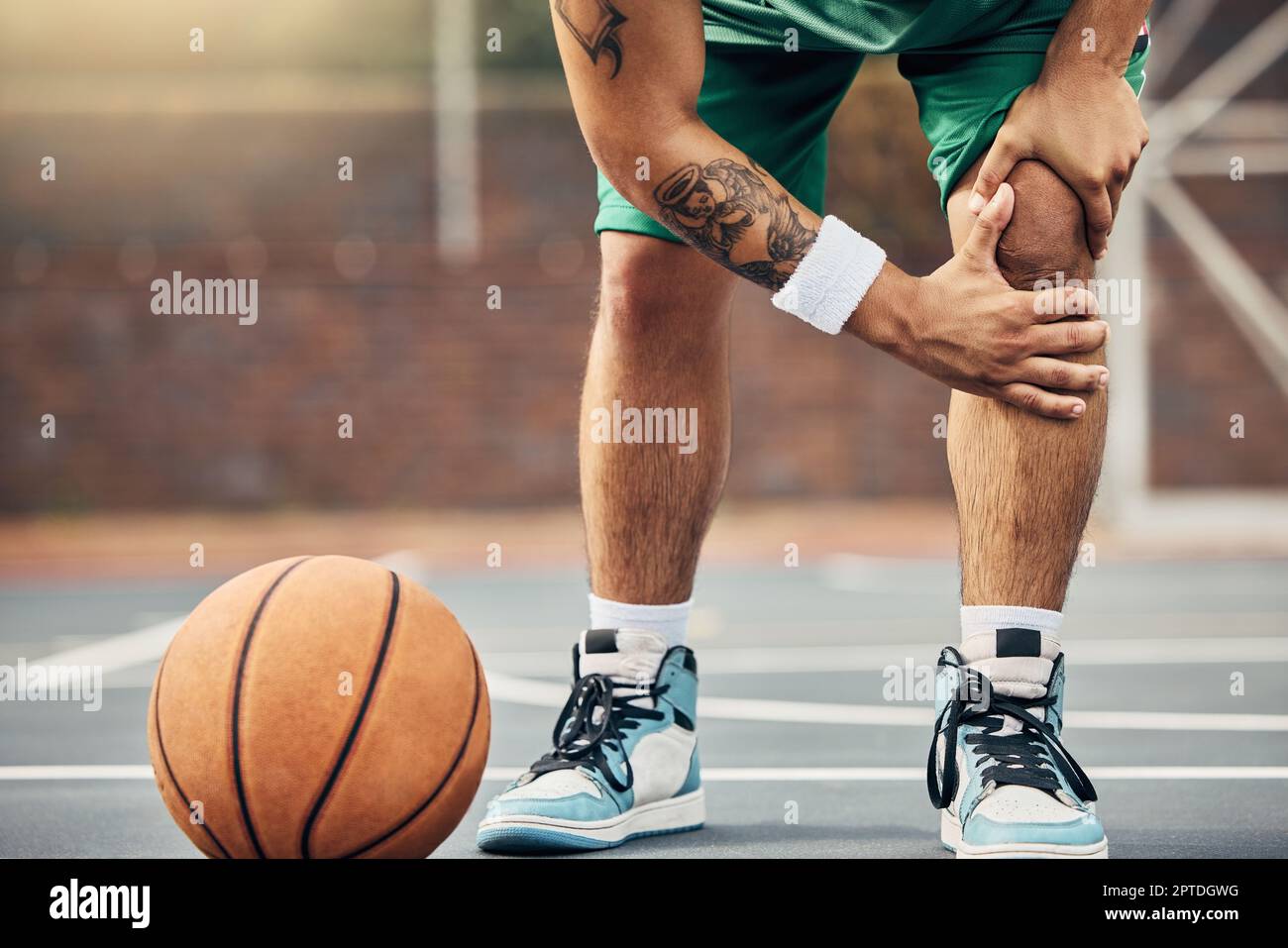 Pallacanestro, atleta e lesioni al ginocchio sul campo da basket durante  una partita all'aperto o un allenamento. Uomo con dolore alle gambe dopo un  incidente sportivo con un rotto Foto stock -