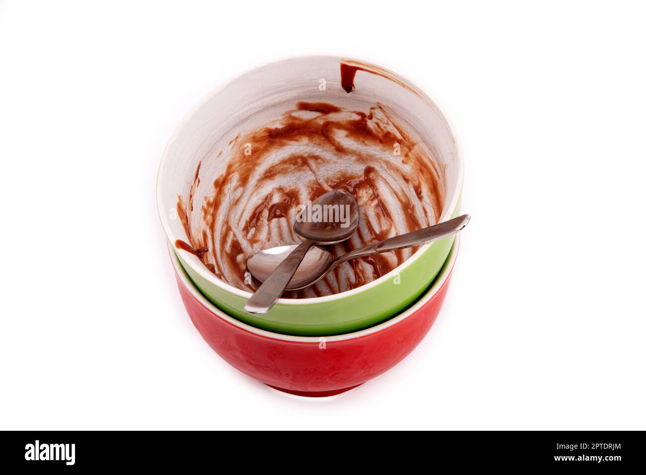 Ciotole vuote per budino di cioccolato con due cucchiai da tè su sfondo bianco. Foto Stock