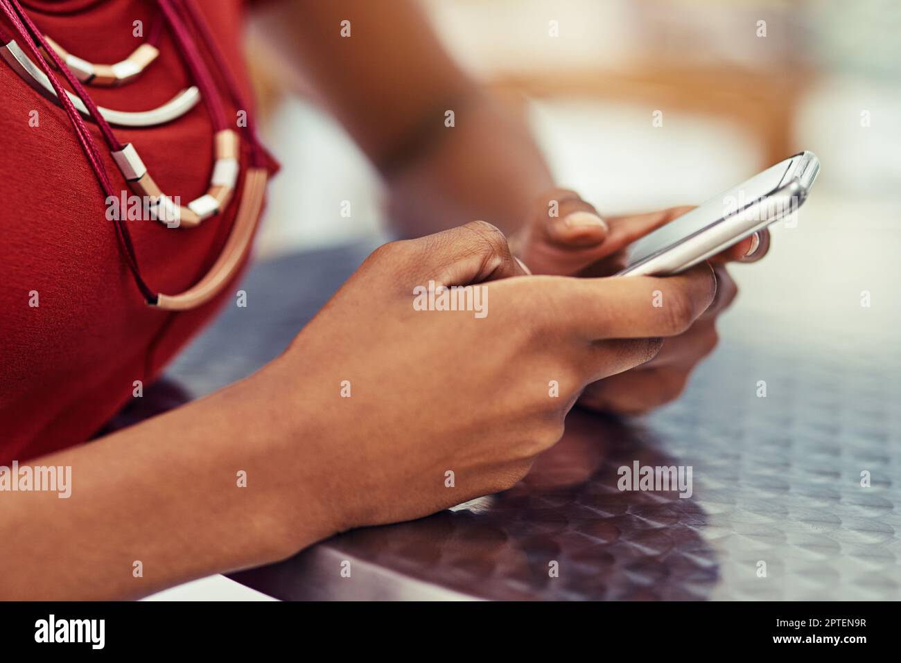 Shes ha ottenuto la tecnologia sotto il suo pollice. donna non identificabile che utilizza uno smartphone al tavolo Foto Stock