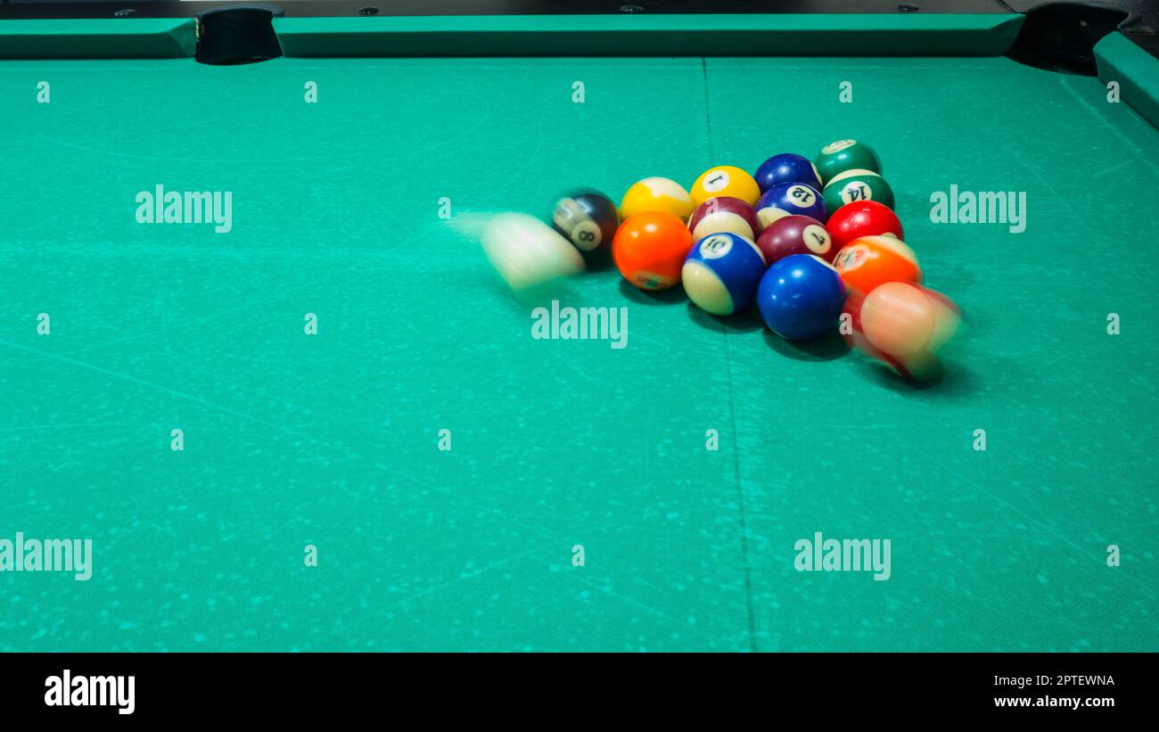 gioco di biliardo con palline colorate e numerate. 8 sfera. tavolo verde e  palle in movimento con stecca da biliardo. panning la palla bianca Foto  stock - Alamy