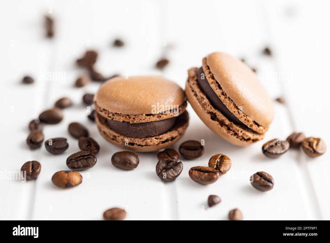 Dolce al macaron. Macaron e chicchi di caffè sul tavolo da cucina. Foto Stock