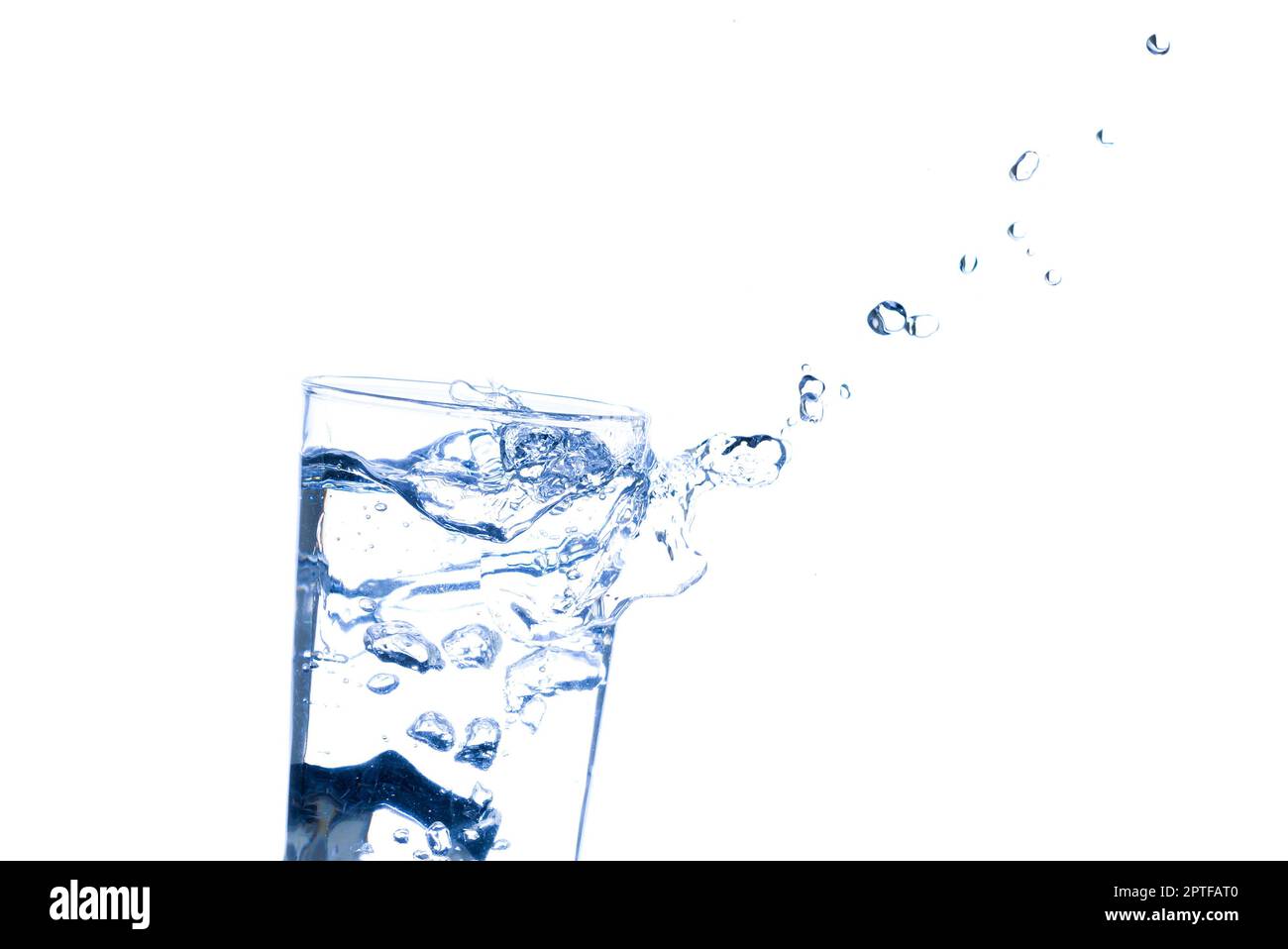 L'immagine di versare acqua potabile, in un bicchiere, che fa sentire rinfrescato su sfondo bianco sfocato, spruzzi d'acqua, acqua frizzante Foto Stock