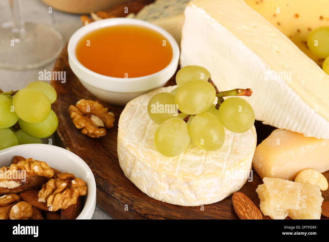 Piatto con gustosi formaggi e uva in tavola, primo piano Foto Stock