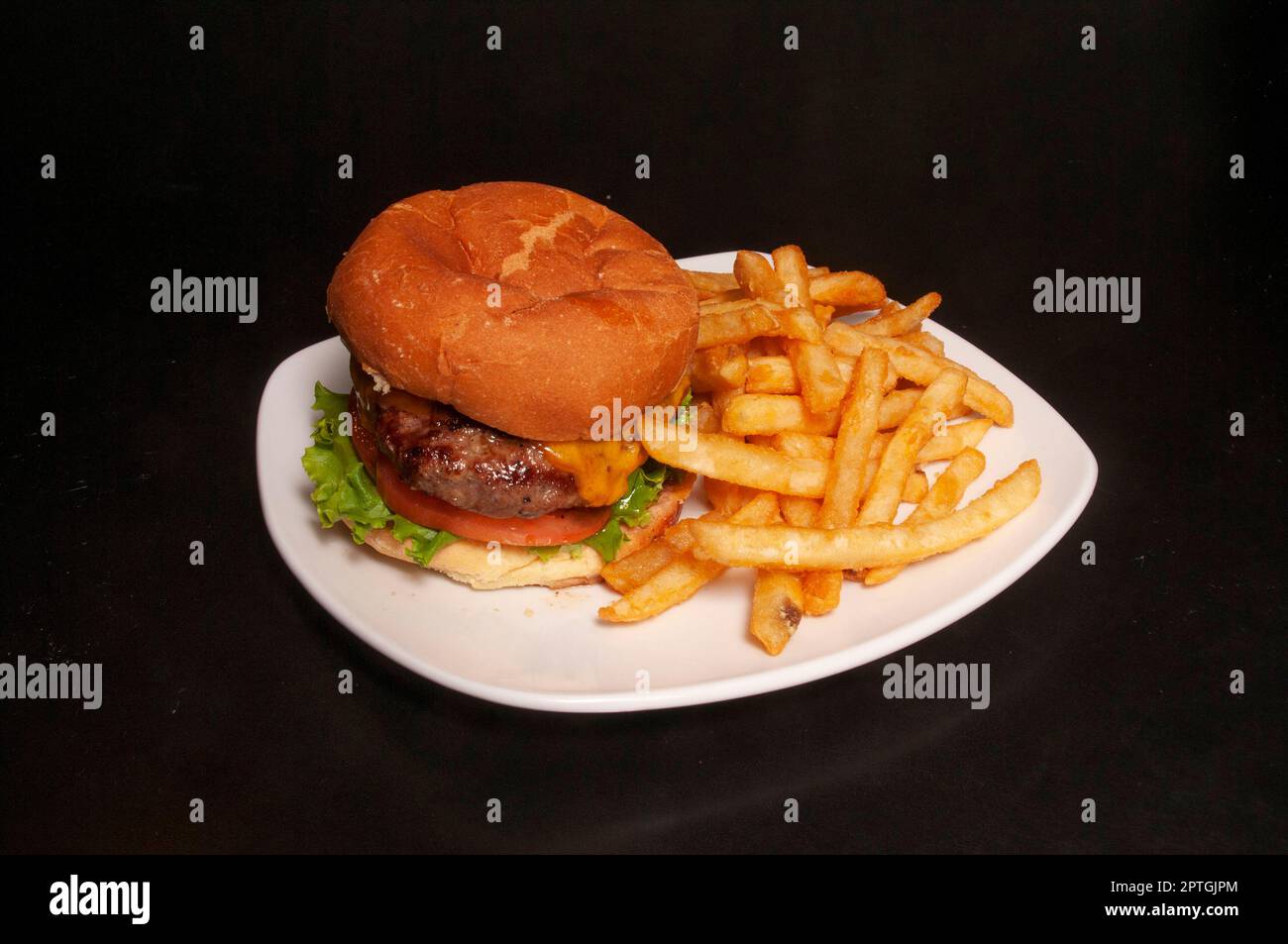 Delizioso cheeseburger e un ordine di patatine fritte. Foto Stock