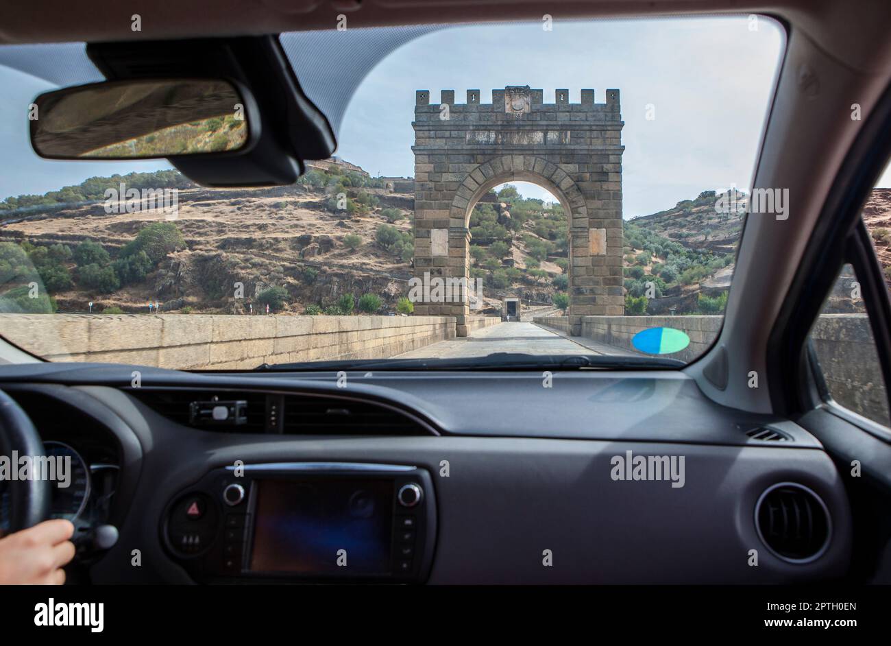 Attraversando il ponte romano dell'Alcantara ancora in uso dal II secolo a.C. Vista dall'interno dell'auto Foto Stock