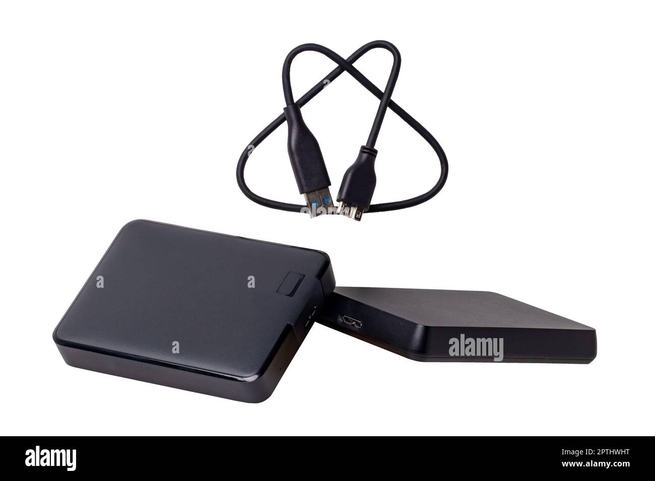 Due dischi rigidi esterni di grande capacità e un cavo USB per il collegamento al computer portatile per il backup di file e informazioni importanti isolati in bianco. Foto Stock