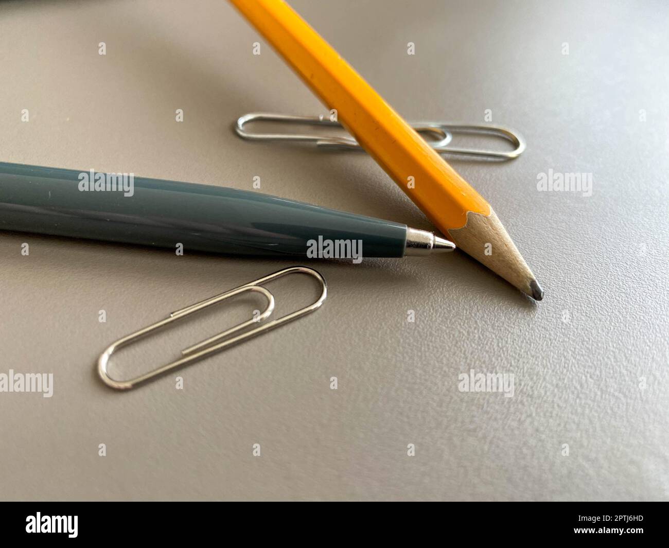 Penna a sfera verde e matita automatiche con graffette per scrivere sulla scrivania dell'ufficio. Lavoro aziendale. Foto Stock