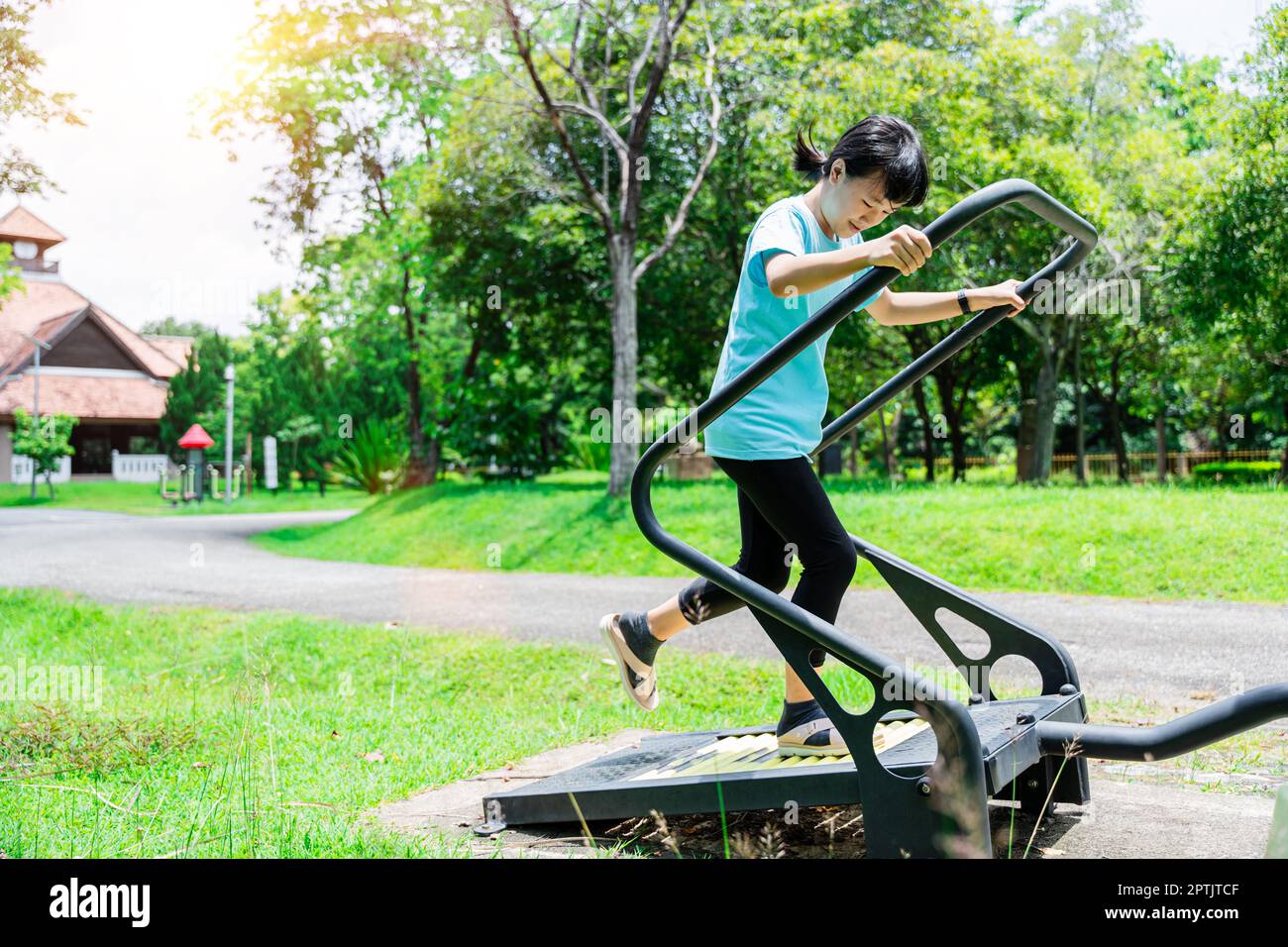Primo piano di una bambina che corre su un tapis roulant per allenarsi nel parco giochi all'aperto. Concetto di fitness e stile di vita sano Foto Stock