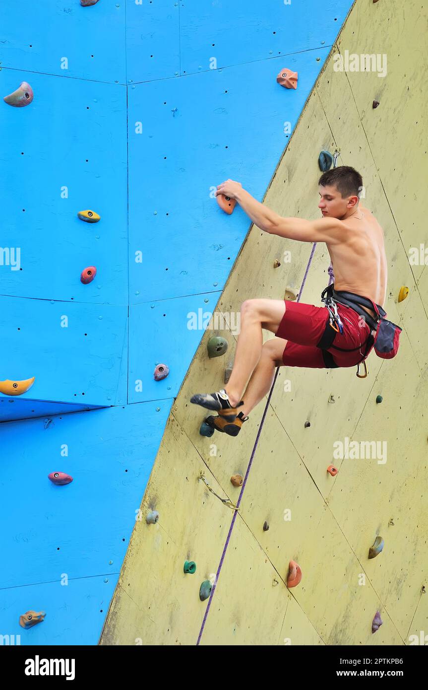 Giovane arrampicatore su un muro Foto Stock