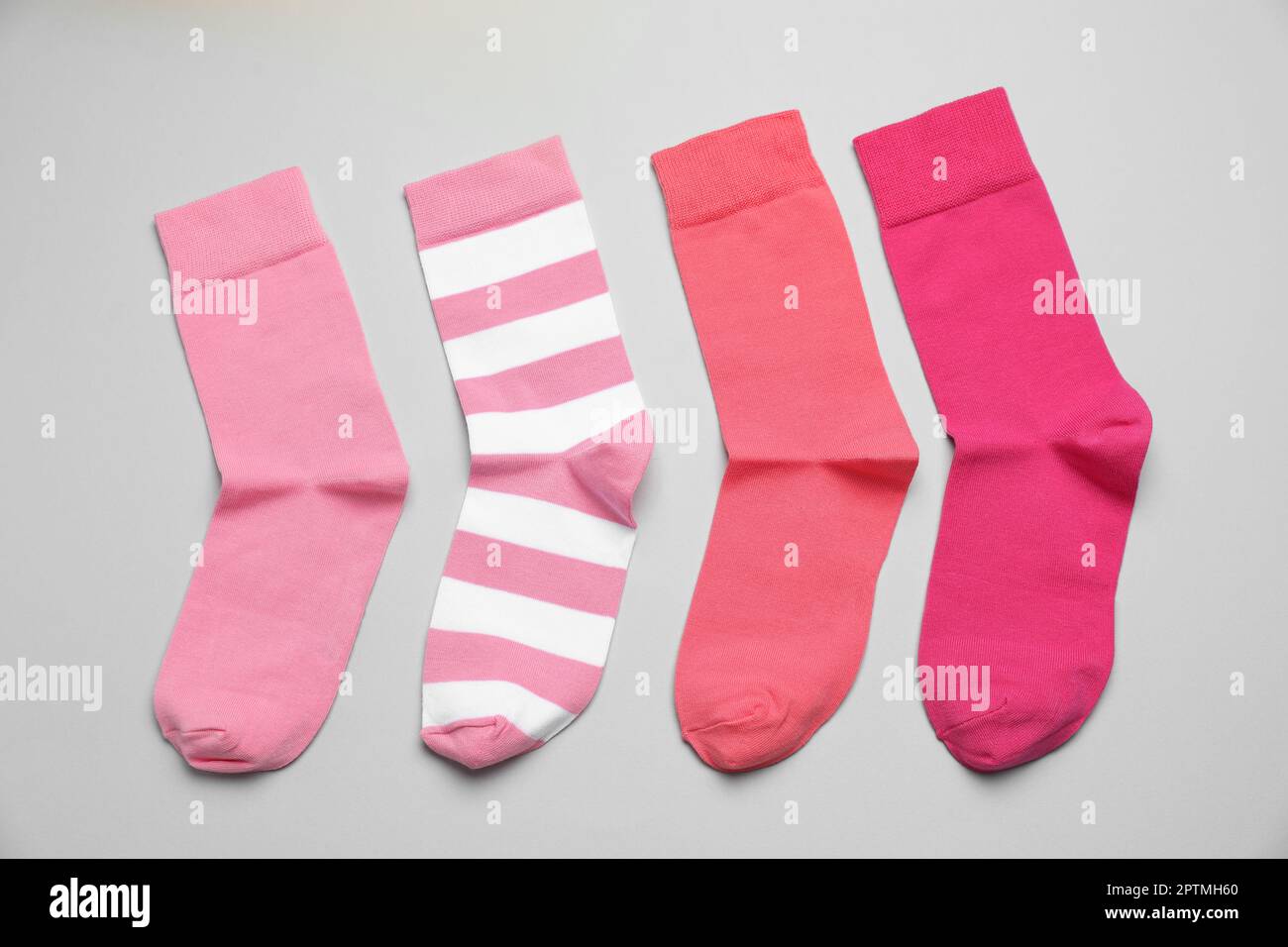 Calzini rosa diversi su sfondo chiaro, piatto Foto Stock