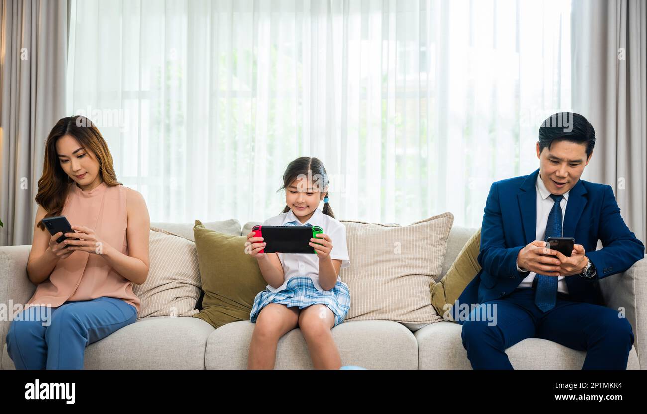 La famiglia non si preoccupa l'uno dell'altro. I genitori asiatici ignorano il loro bambino e guardando il loro telefono cellulare a casa, dipendenza gadget overuse internet così Foto Stock