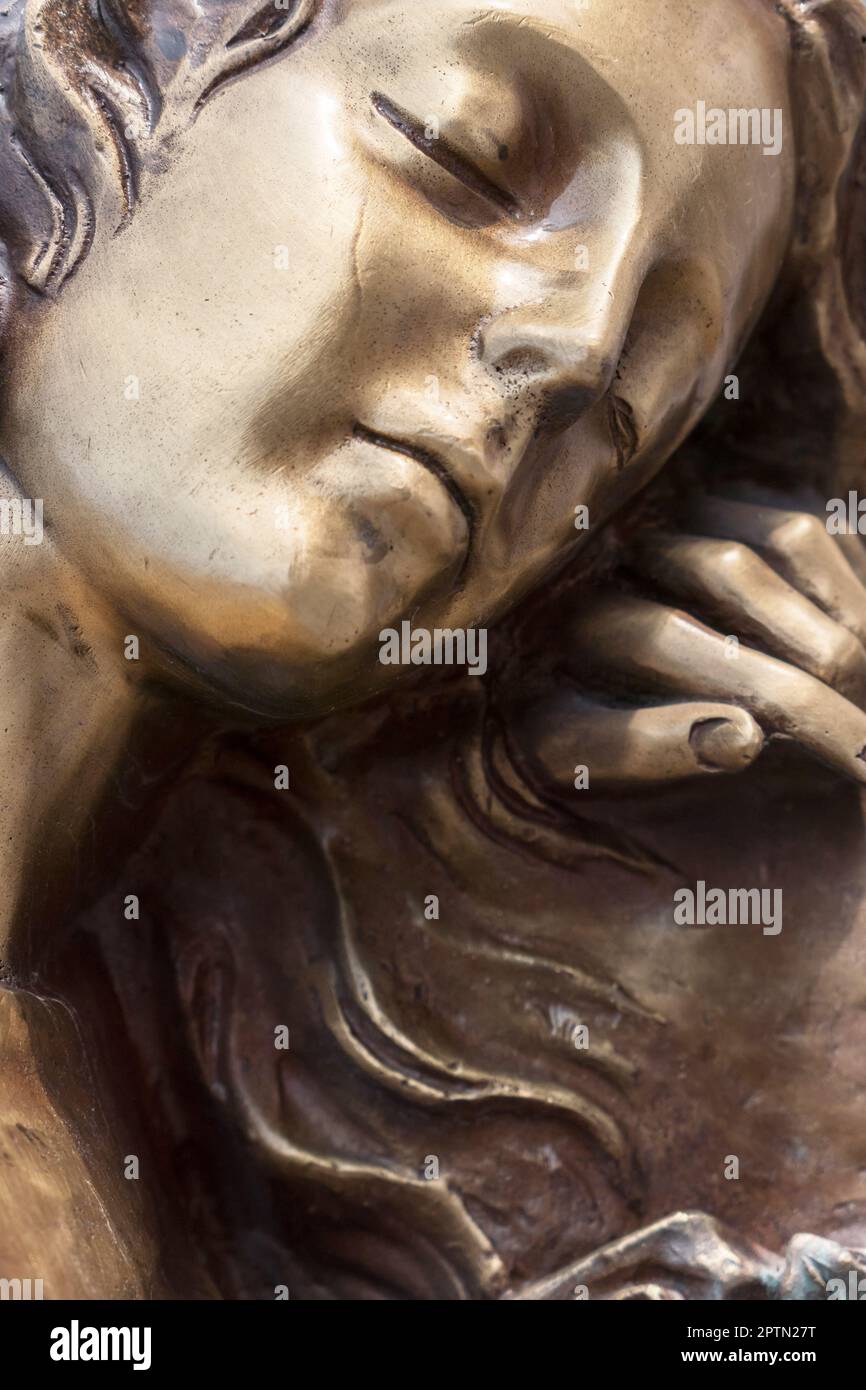 Scultura vintage di donna triste in dolore. Statua di bronzo della Vergine Maria. Religione, fede, sofferenza, concetto di morte. Foto Stock