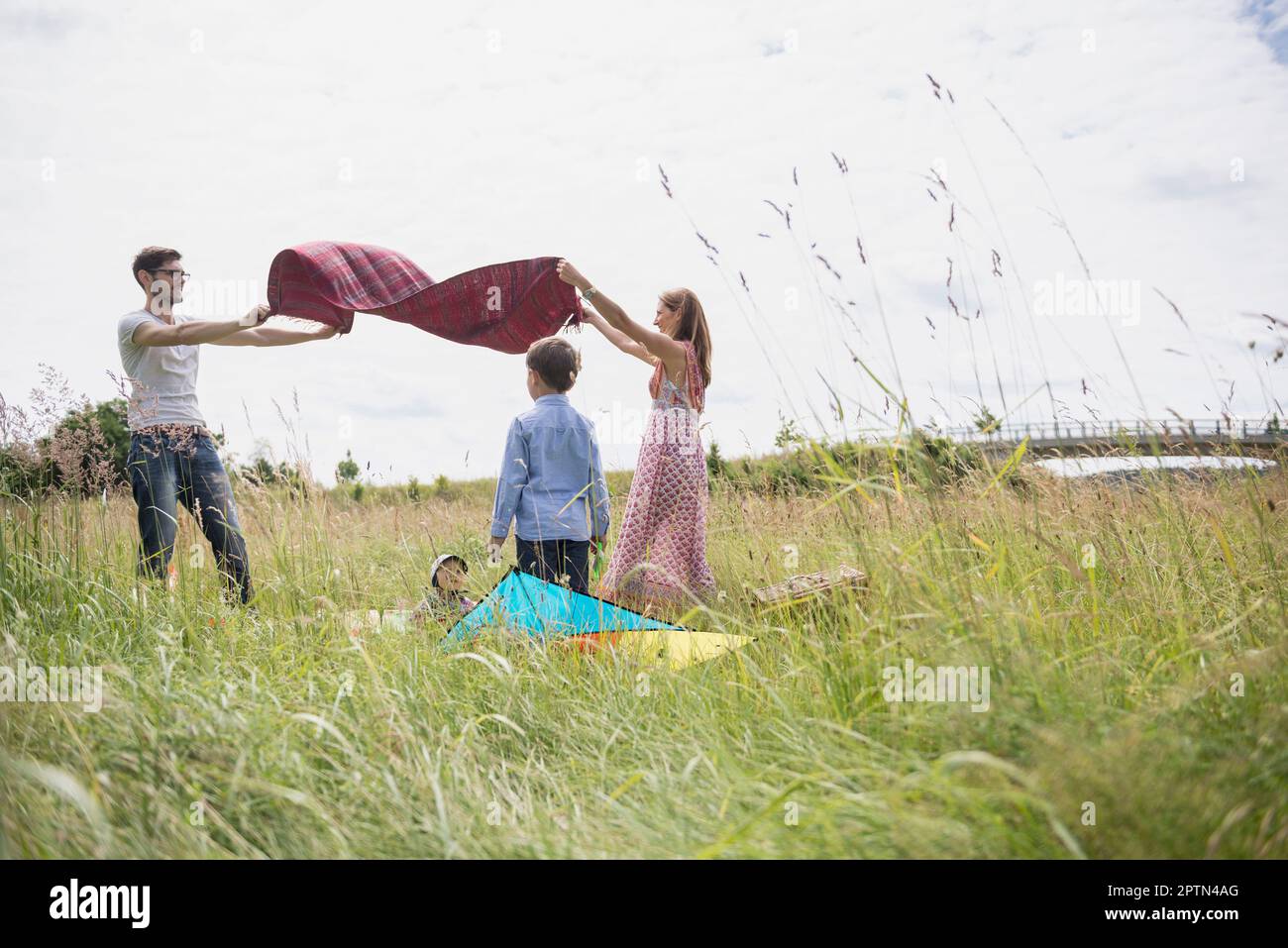 Coperta da pic-nic in famiglia spargendo su prato in campagna, Baviera, Germania Foto Stock