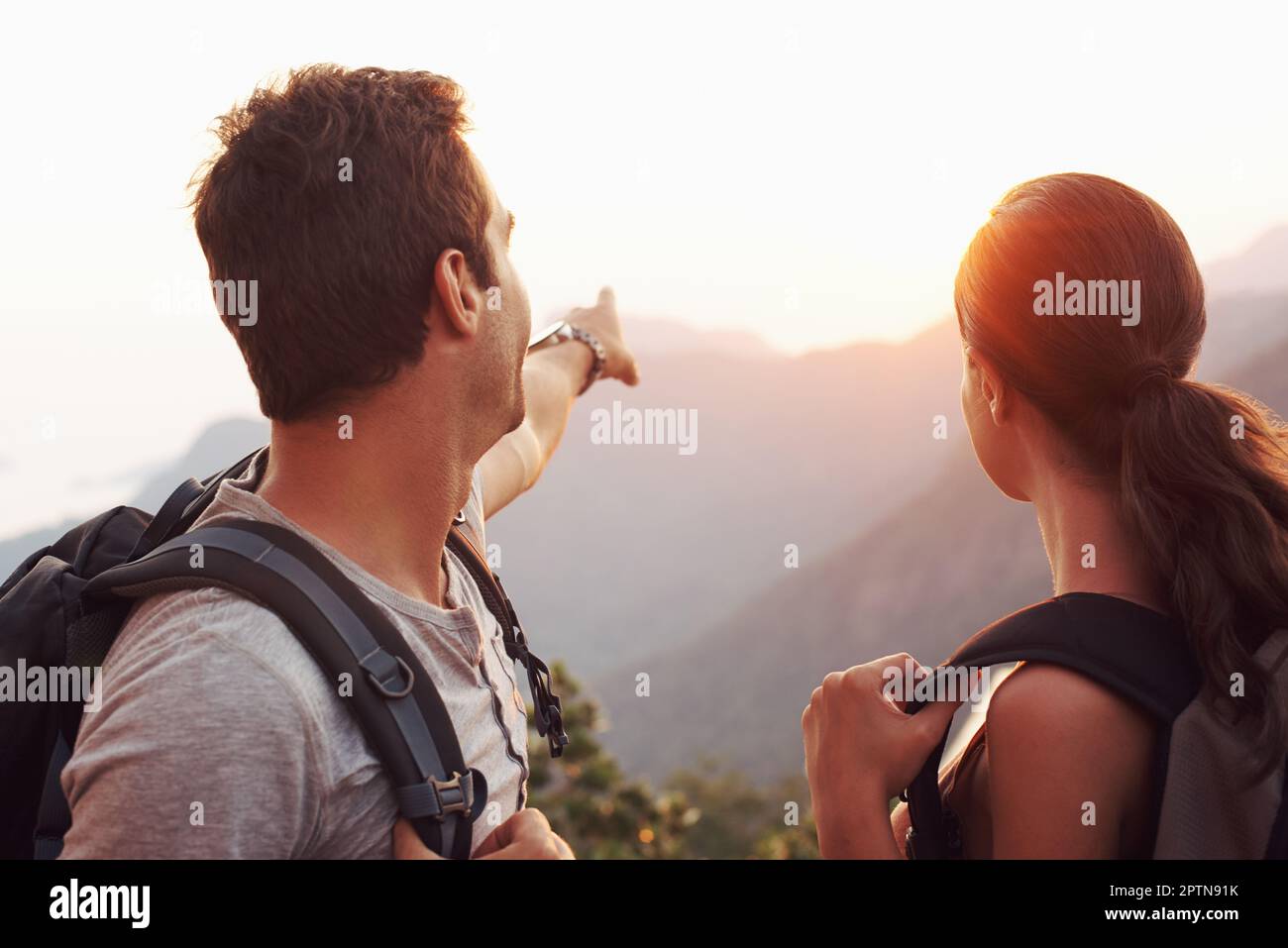 Sono stati diretti a quel punto là... Un giovane che indica verso l'orizzonte mentre la sua ragazza guarda sopra Foto Stock