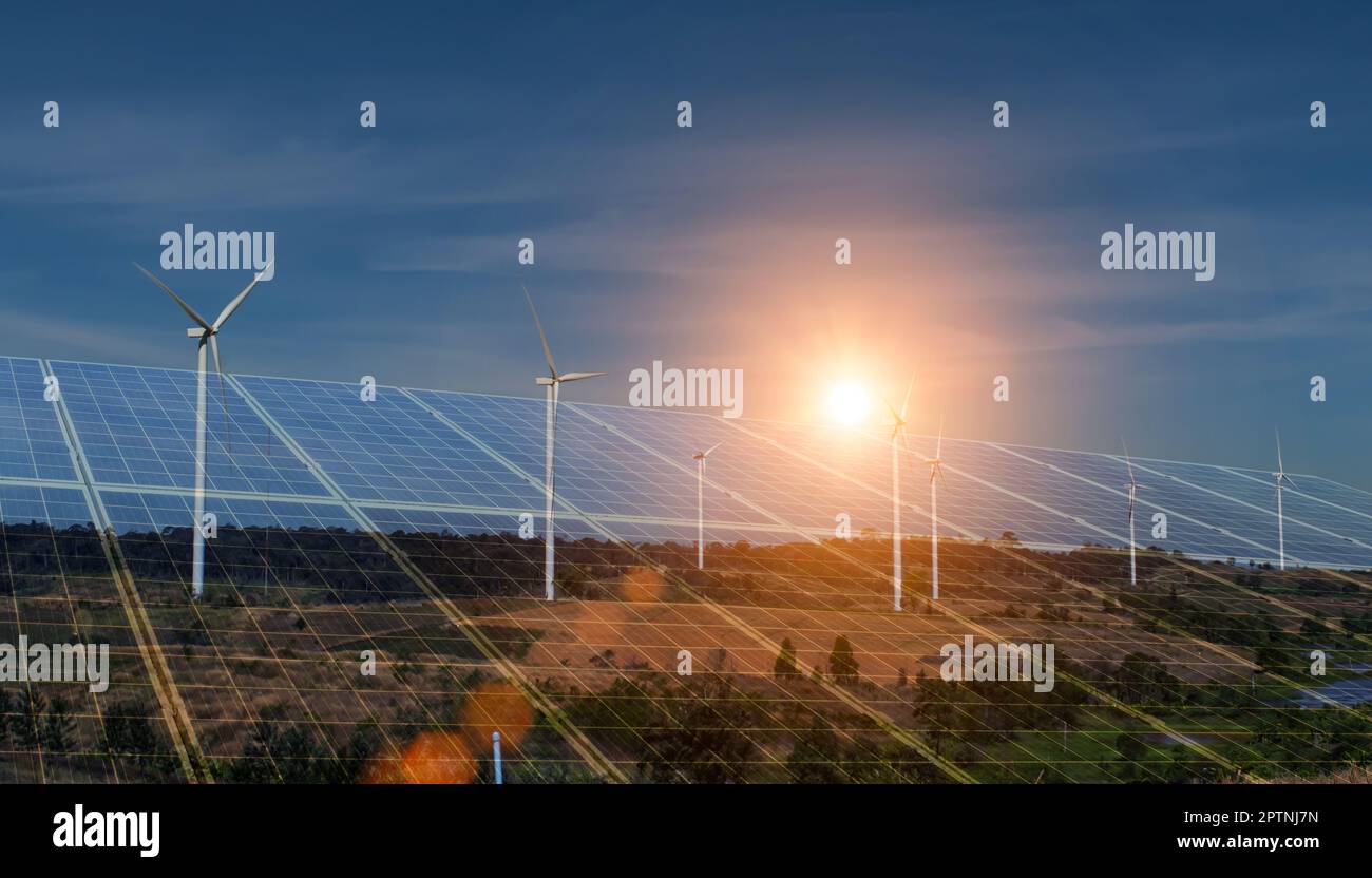 Concetto di energia sostenibile per l'ambiente. Pannelli solari e turbine eoliche che generano elettricità. Celle fotovoltaiche al tramonto. Foto Stock