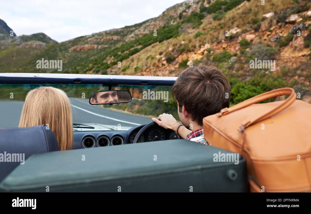 Una strada aperta...la vista posteriore di una coppia che fa un viaggio su strada in una cabriolet Foto Stock