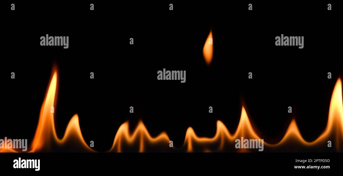 Primo piano linea di fiamme isolate su sfondo nero, angolo basso, vista laterale Foto Stock