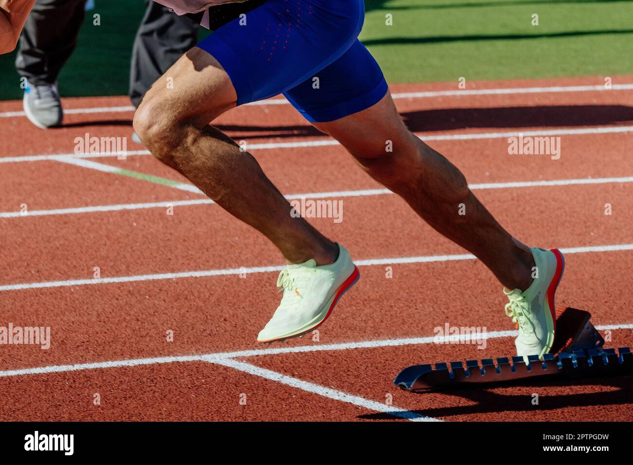 primo piano gambe maschio runner in blocchi di partenza corsa sprint, campionati di atletica estiva Foto Stock
