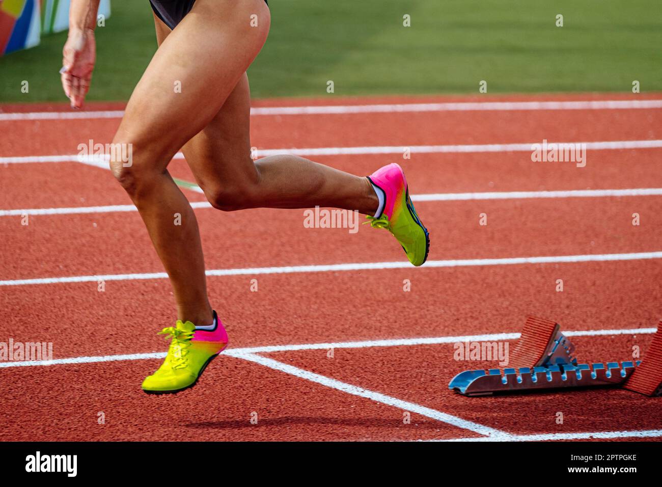 gambe femmina runner che inizia a correre in gara sprint stadio pista rossa, campionati di atletica estiva Foto Stock