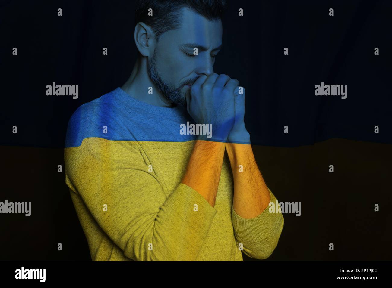Doppia esposizione della bandiera nazionale e l'uomo che prega. Fermare la guerra in Ucraina Foto Stock