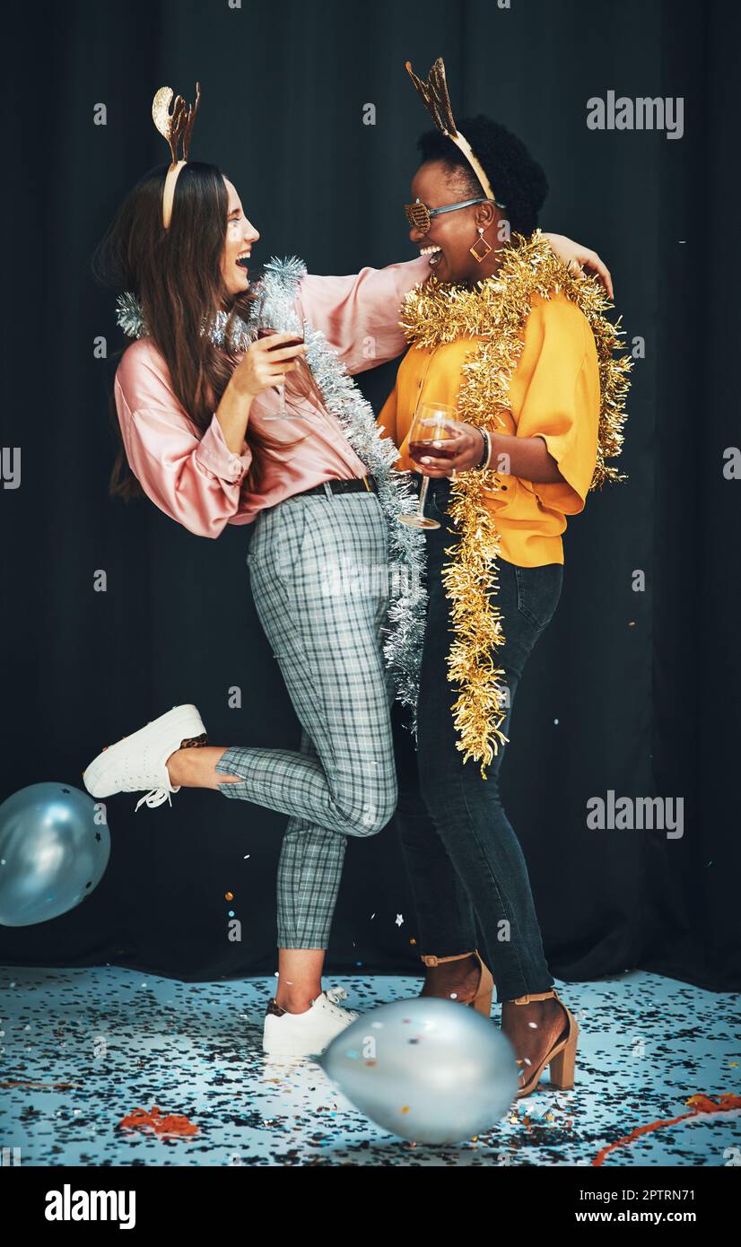 Donne amici, festa e notte con palloncini, sidro o vino nel nuovo anno, celebrazione o felicità. Donna diversità, abbraccio e bicchiere per bevande, felice o Foto Stock