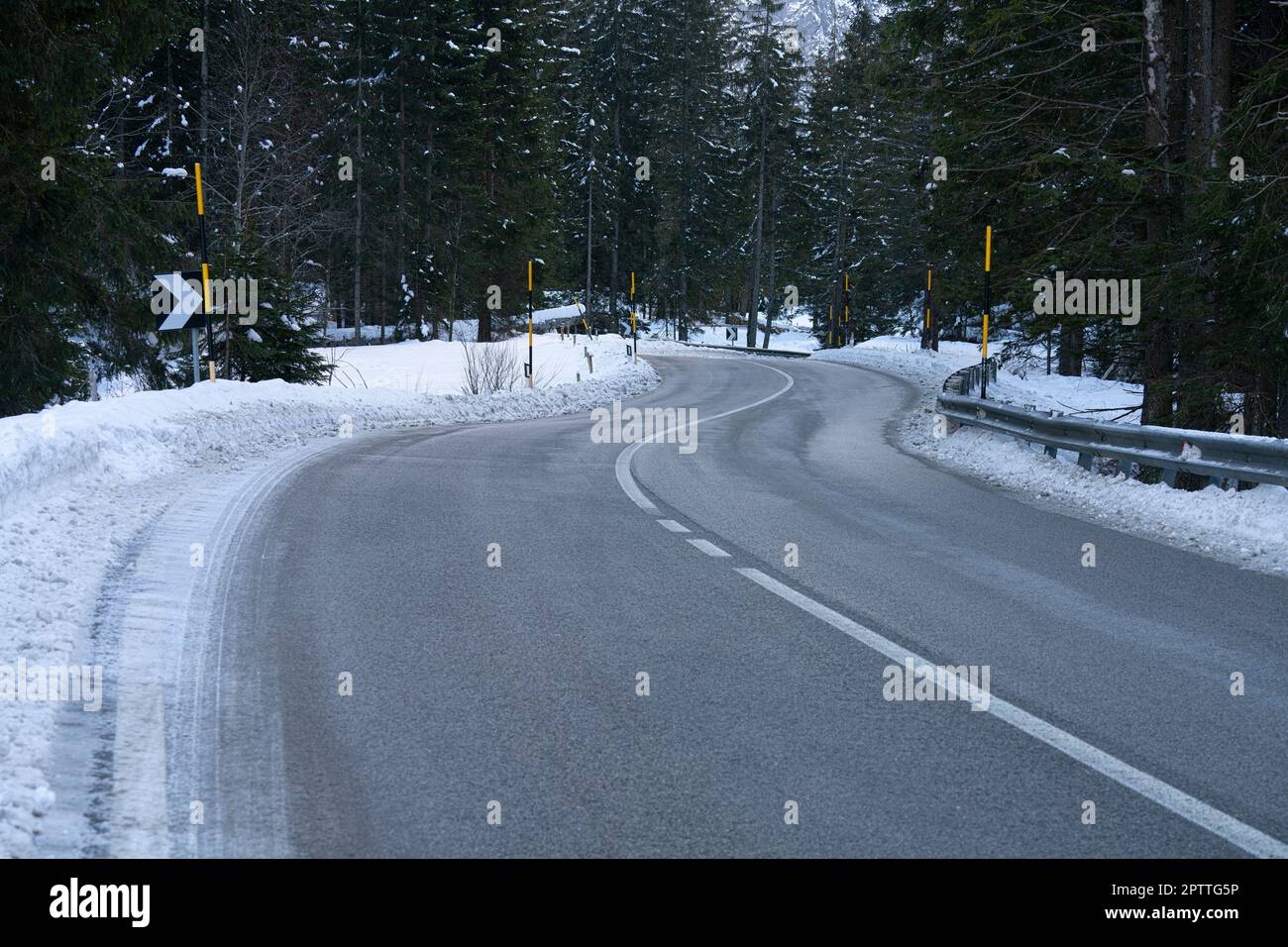 Vista interna di una strada in una valle delle Alpi italiane con neve Foto Stock