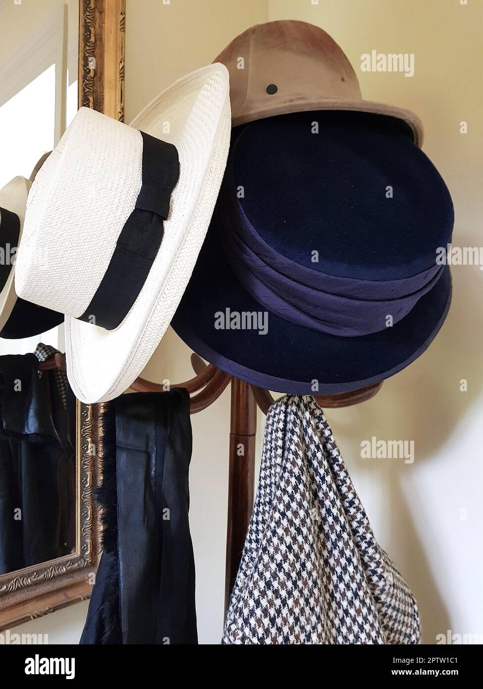 Particolare di un supporto per cappello vintage con cappelli e cappotti. Foto Stock