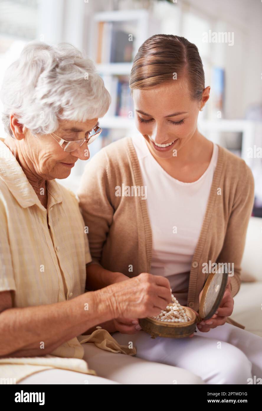 Questo è stato nella nostra famiglia per generazioni. una donna anziana che dona alla figlia una collana di perle Foto Stock