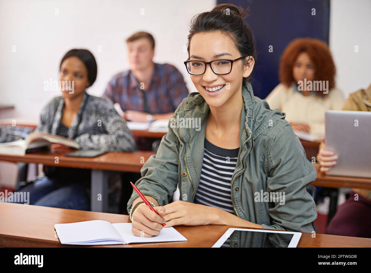 Im investendo nel mio futuro. Ritratto di una felice studentessa seduta alla sua scrivania Foto Stock