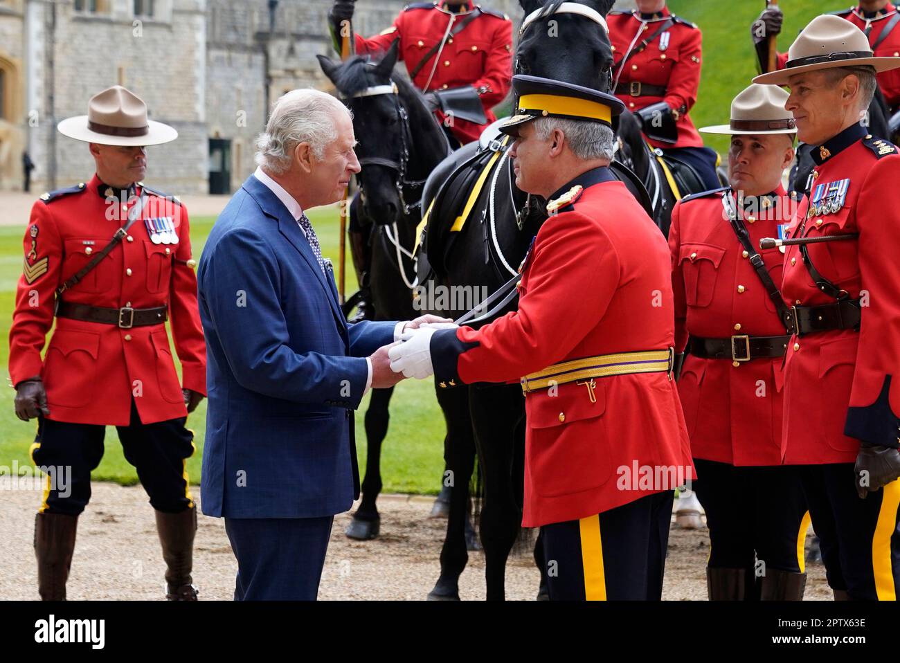Re Carlo III (seconda a sinistra) è ufficialmente presentato con 'Noble', un cavallo che gli è stato dato dalla Royal Canadian Mounted Police (RCMP) all'inizio di quest'anno, in quanto accetta formalmente il ruolo di commissario in capo della RCMP durante una cerimonia nel quadrilatero del Castello di Windsor, Berkshire. Data immagine: Venerdì 28 aprile 2023. Foto Stock