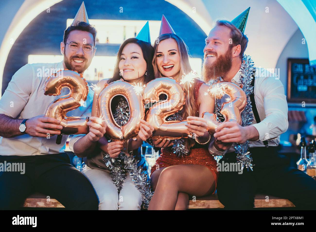 donne e uomini che festeggiano il nuovo anno 2023 con il vino Foto Stock