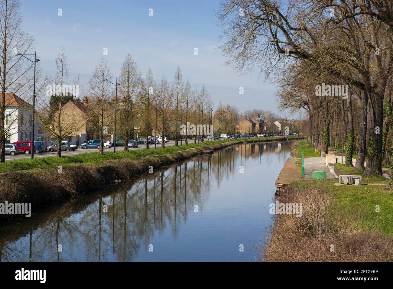 Vista primaverile del Canal de Transit ad Abbeville, nel dipartimento della Somme della Francia settentrionale. Tranquillo canale alberato con cielo blu chiaro, Foto Stock