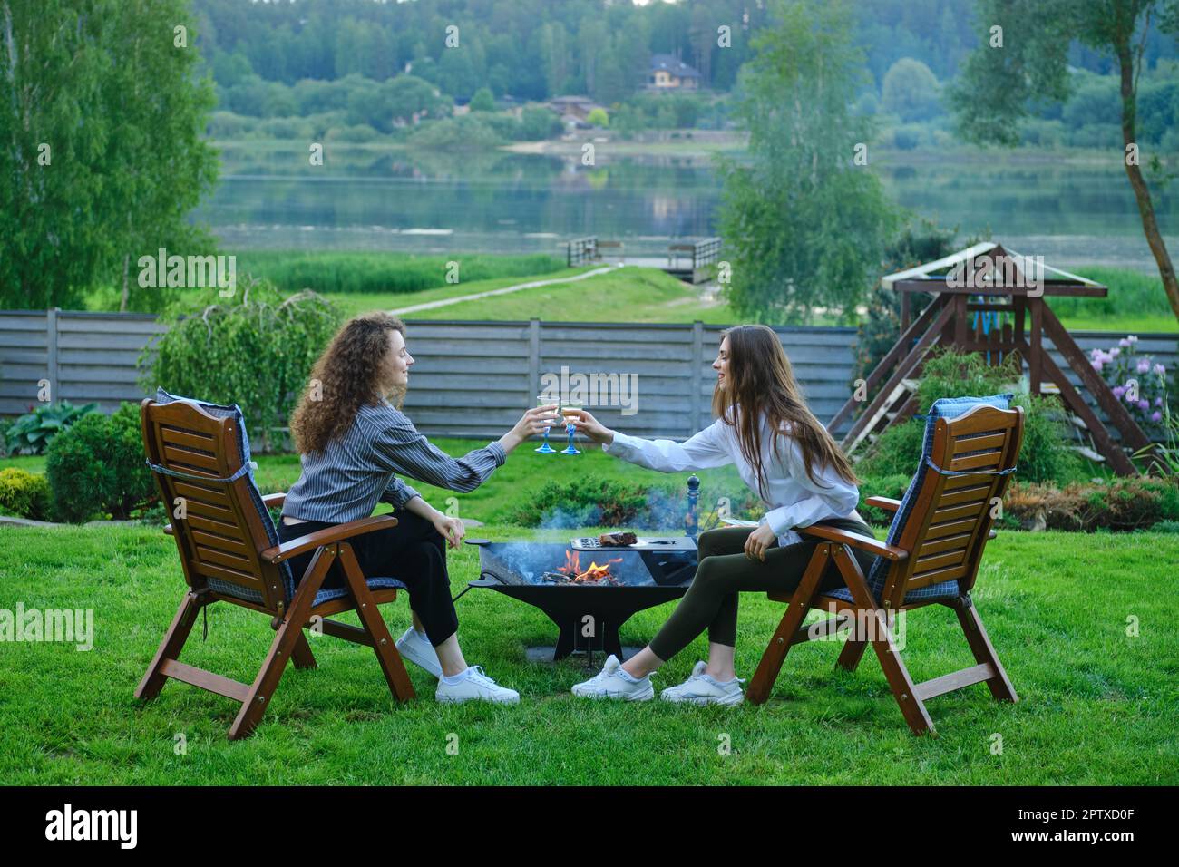 Buone donne che tostano vino bianco all'aperto Foto Stock