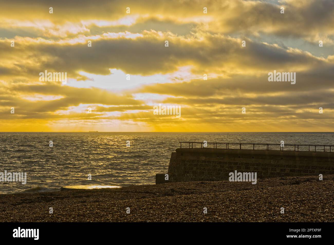 Spiaggia di ciottoli e frangiflutti al tramonto, Brighton, East Sussex, Inghilterra Foto Stock