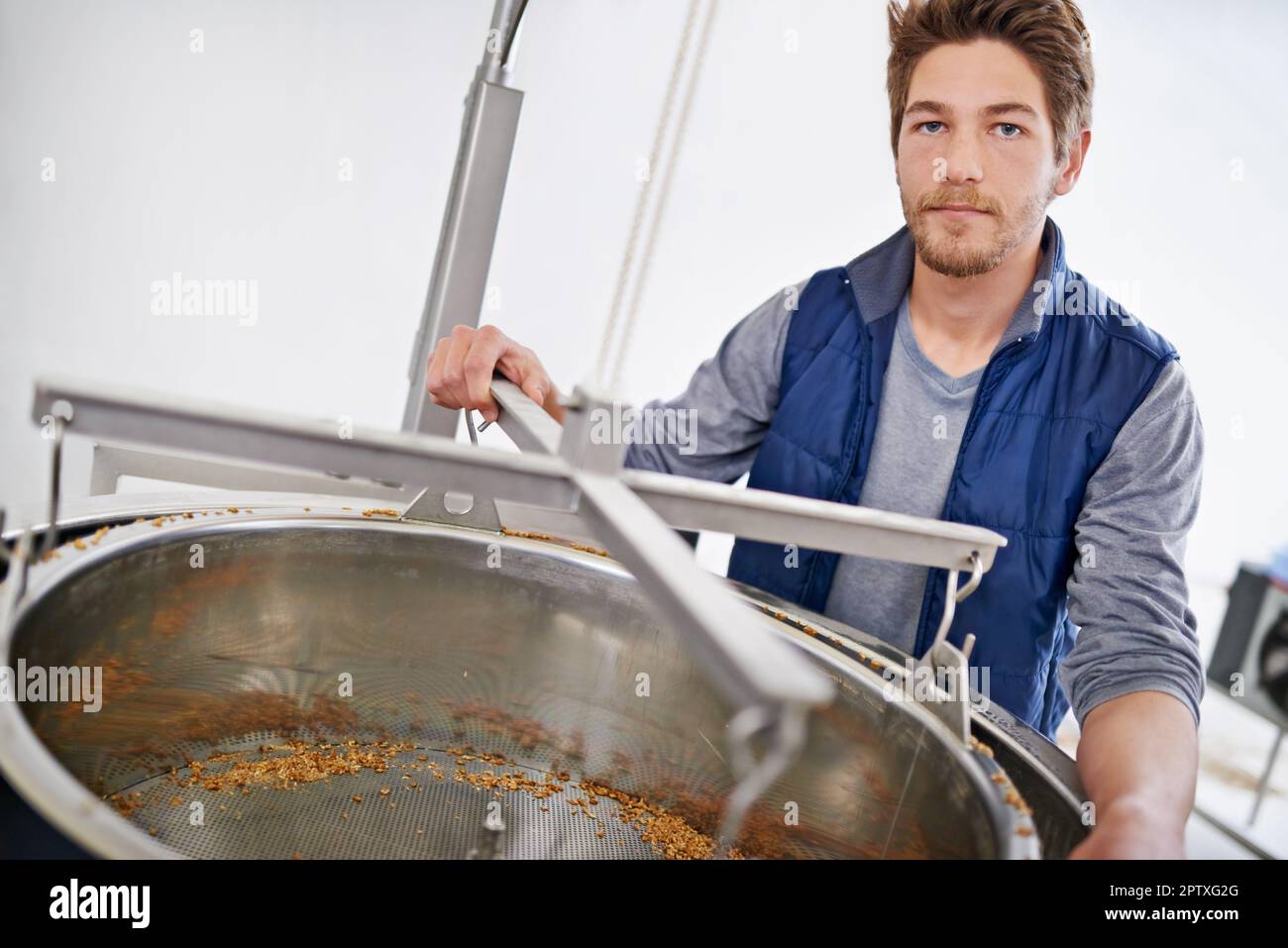 Preparazione di una buona birra. Ritratto di un uomo che lavora in una microbirreria Foto Stock