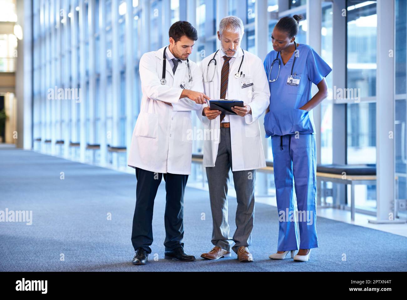 Ottenere una seconda opinione. Un'équipe medica in piedi nel corridoio dell'ospedale Foto Stock