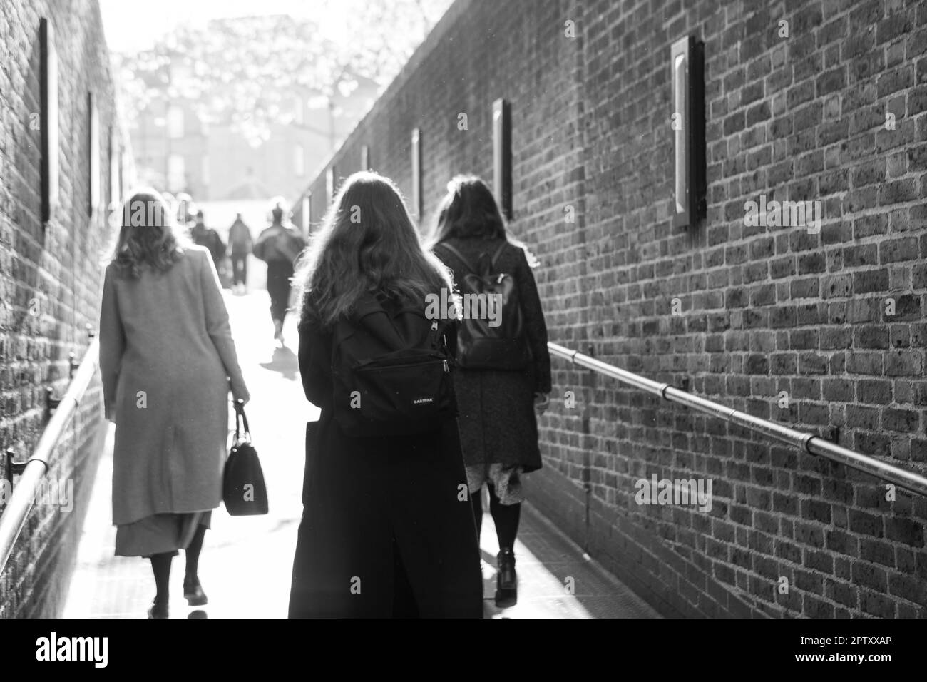Londra, Regno Unito, 25 aprile 2023: Alla stazione della metropolitana di Pimlico tre donne salgono sulla rampa per uscire dalla stazione sulla strada per lavorare. Raggi di sole giù su di loro e foglie di primavera su un albero può essere visto in lontananza. Anna Watson/Alamy Foto Stock
