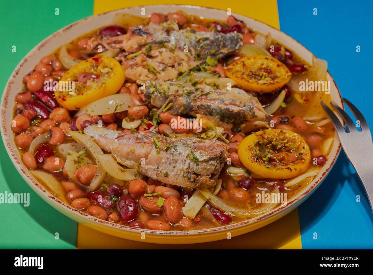 Piatto sano di fagioli misti brasati con sardine. Foto Stock