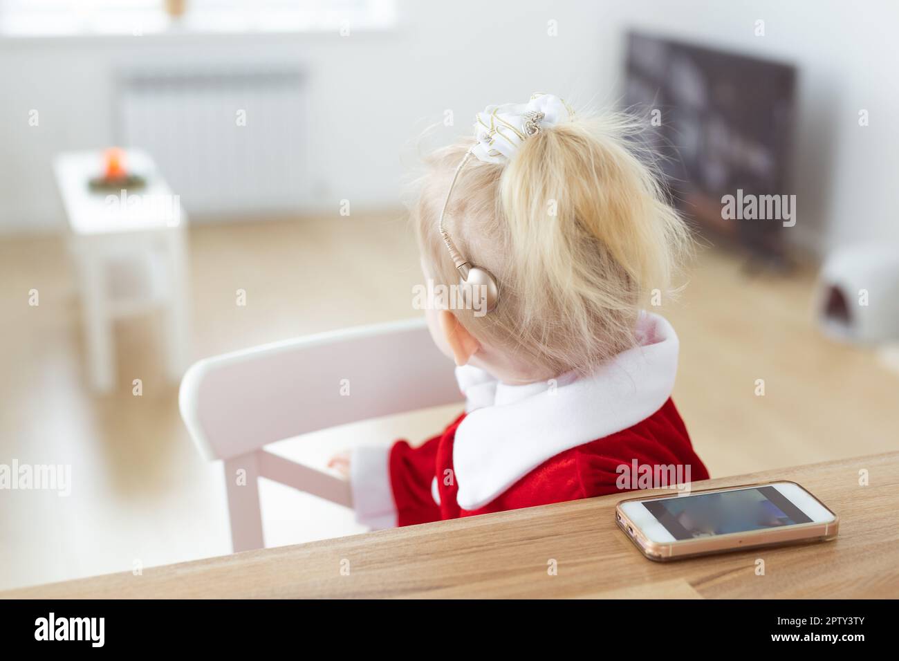 Bambina sorda con impianto cocleare soggiorno - sordità diversità e innovative tecnologie mediche per apparecchi acustici Foto Stock