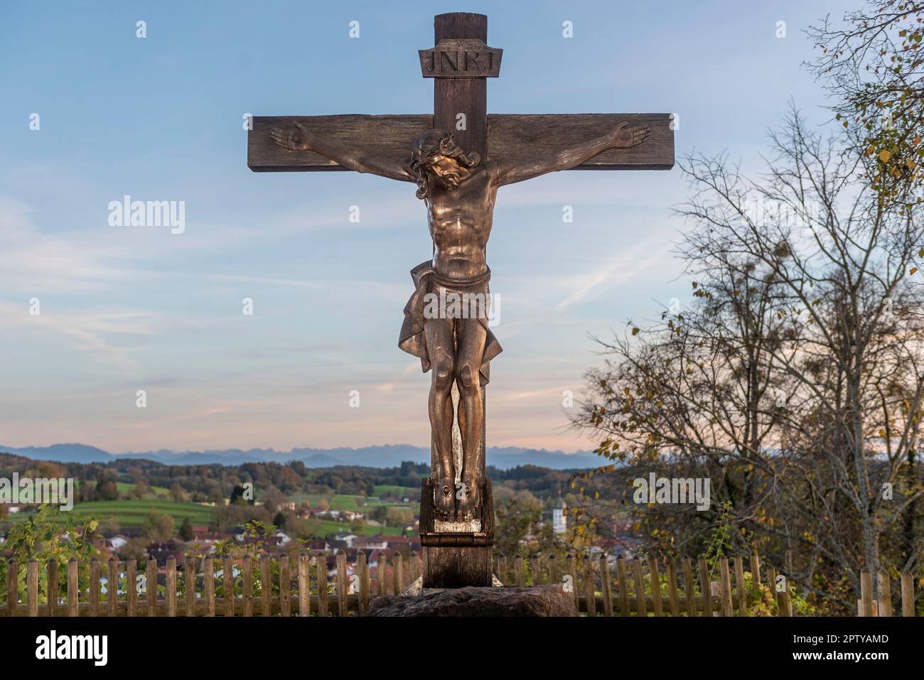 Gesù crocifisso su croce di legno nel monastero di Andechs con cielo, orizzonte e colline alpine bavaresi Foto Stock