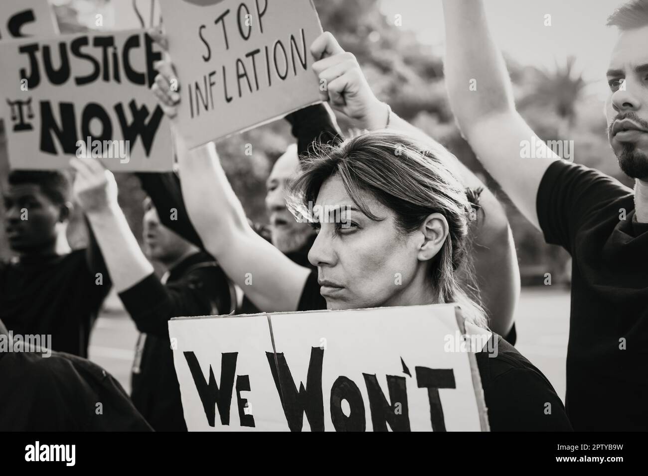 Persone multirazziali che protestano contro la crisi finanziaria e l'inflazione globale - concetto di attivismo della giustizia economica - montaggio in bianco e nero Foto Stock