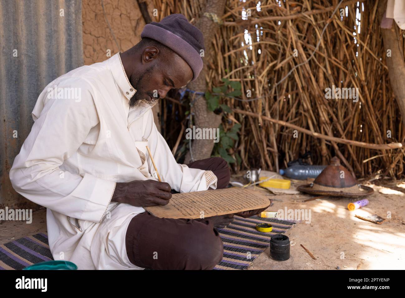 Un uomo IDP pratica la calligrafia islamica nella regione di Segou, Mali, Africa occidentale. 2022 siccità del Mali e crisi della fame. Foto Stock