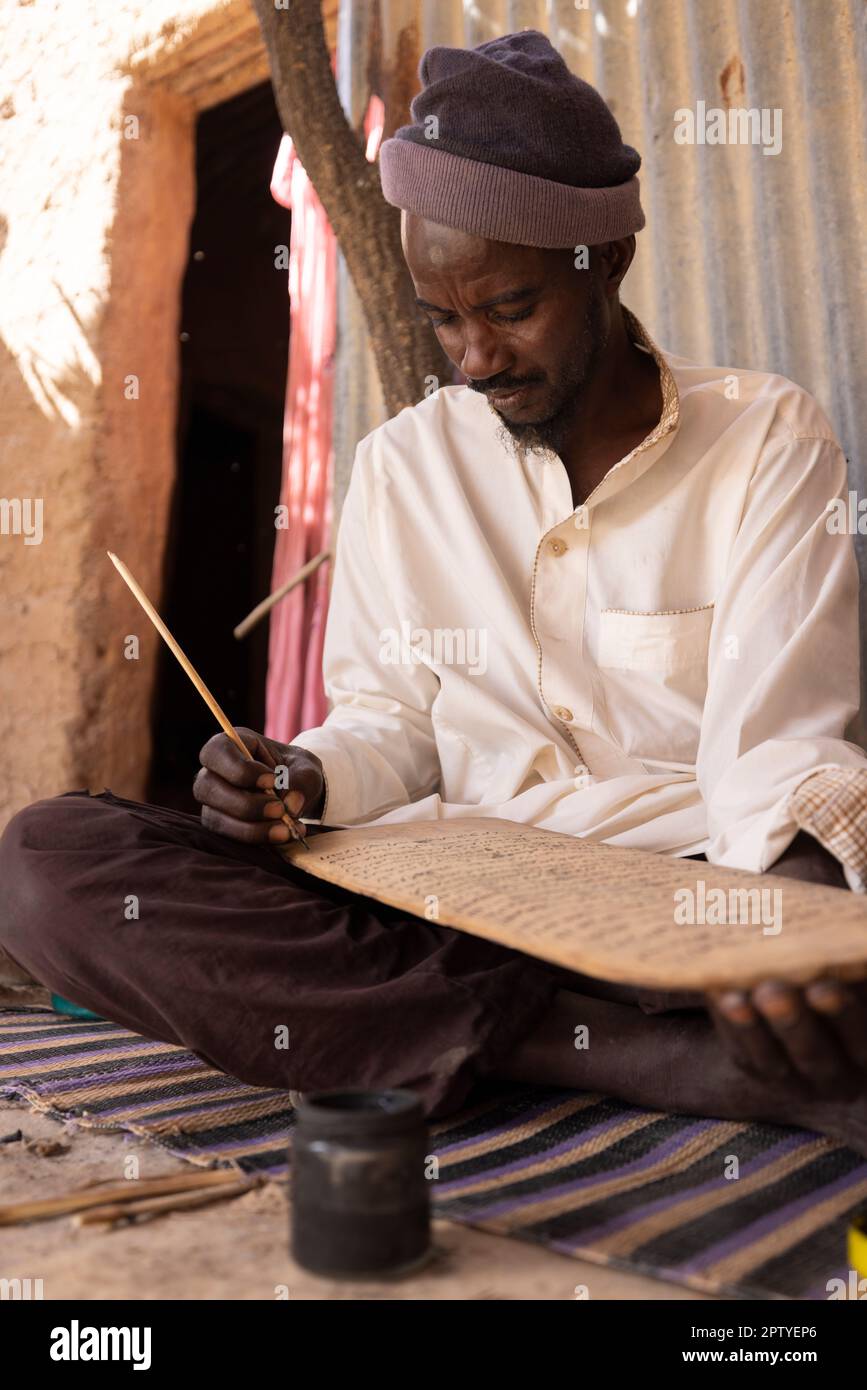 Un uomo IDP pratica la calligrafia islamica nella regione di Segou, Mali, Africa occidentale. 2022 siccità del Mali e crisi della fame. Foto Stock