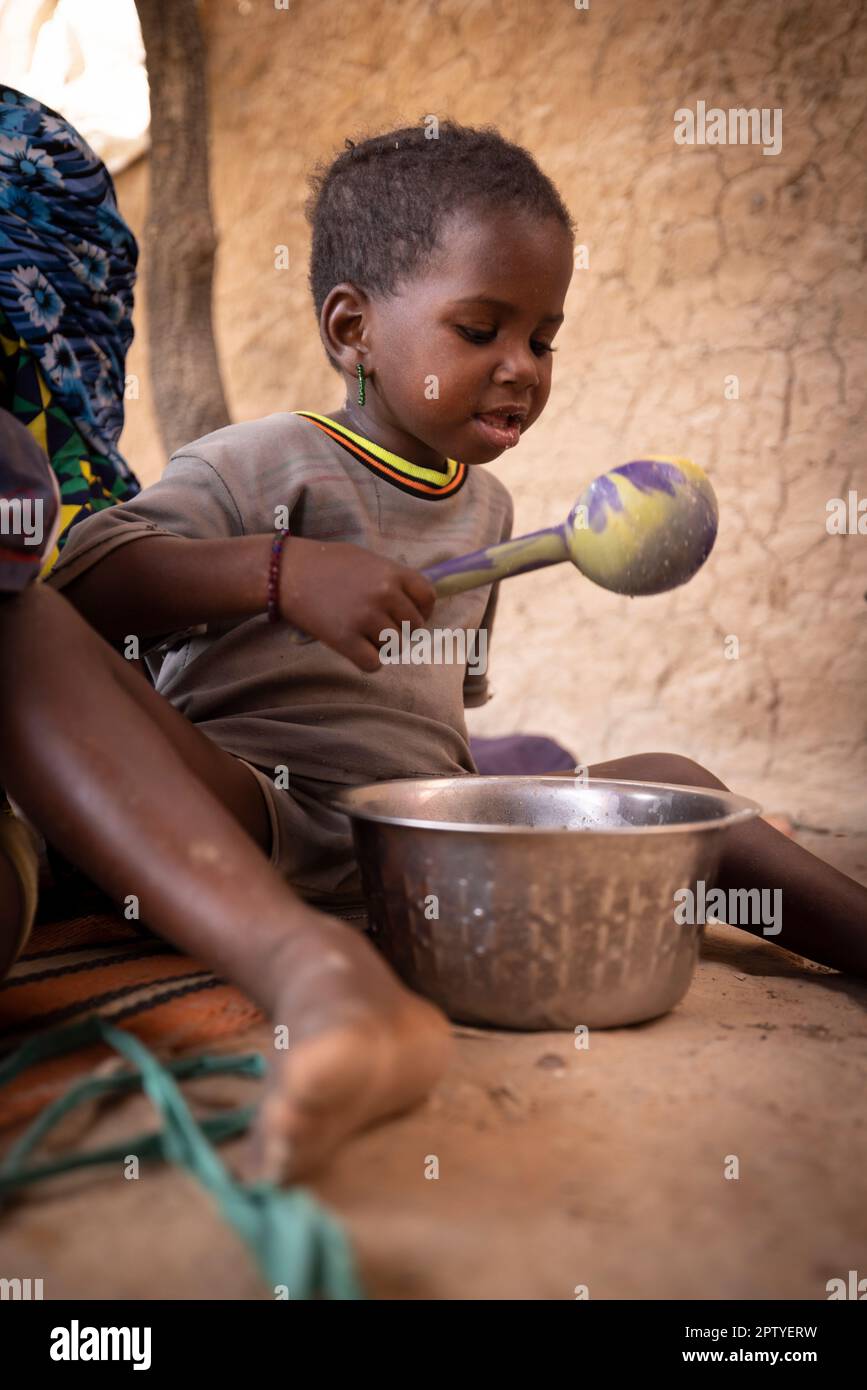 Ragazza Fulani IDP che mangia porridge mattutino nella regione di Segou, Mali, Africa occidentale. 2022 siccità del Mali e crisi della fame. Foto Stock