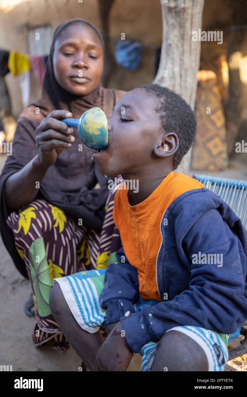 Una madre nutre suo figlio che vive con paralisi cerebrale nella regione di Segou, Mali, Africa occidentale. 2022 siccità del Mali e crisi della fame. Foto Stock