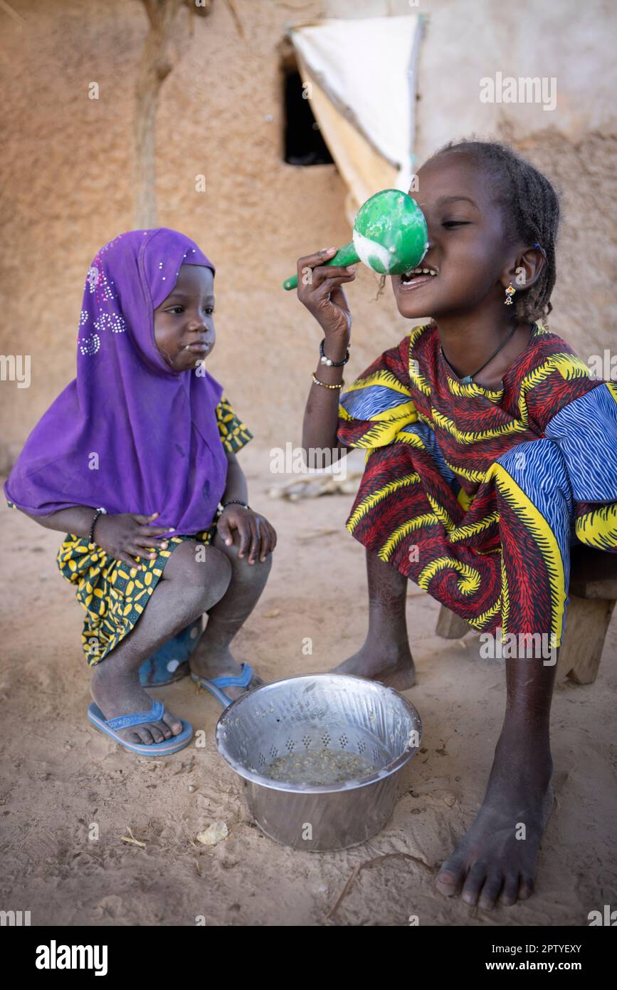 Ragazza Fulani IDP che mangia porridge mattutino nella regione di Segou, Mali, Africa occidentale. 2022 siccità del Mali e crisi della fame. Foto Stock