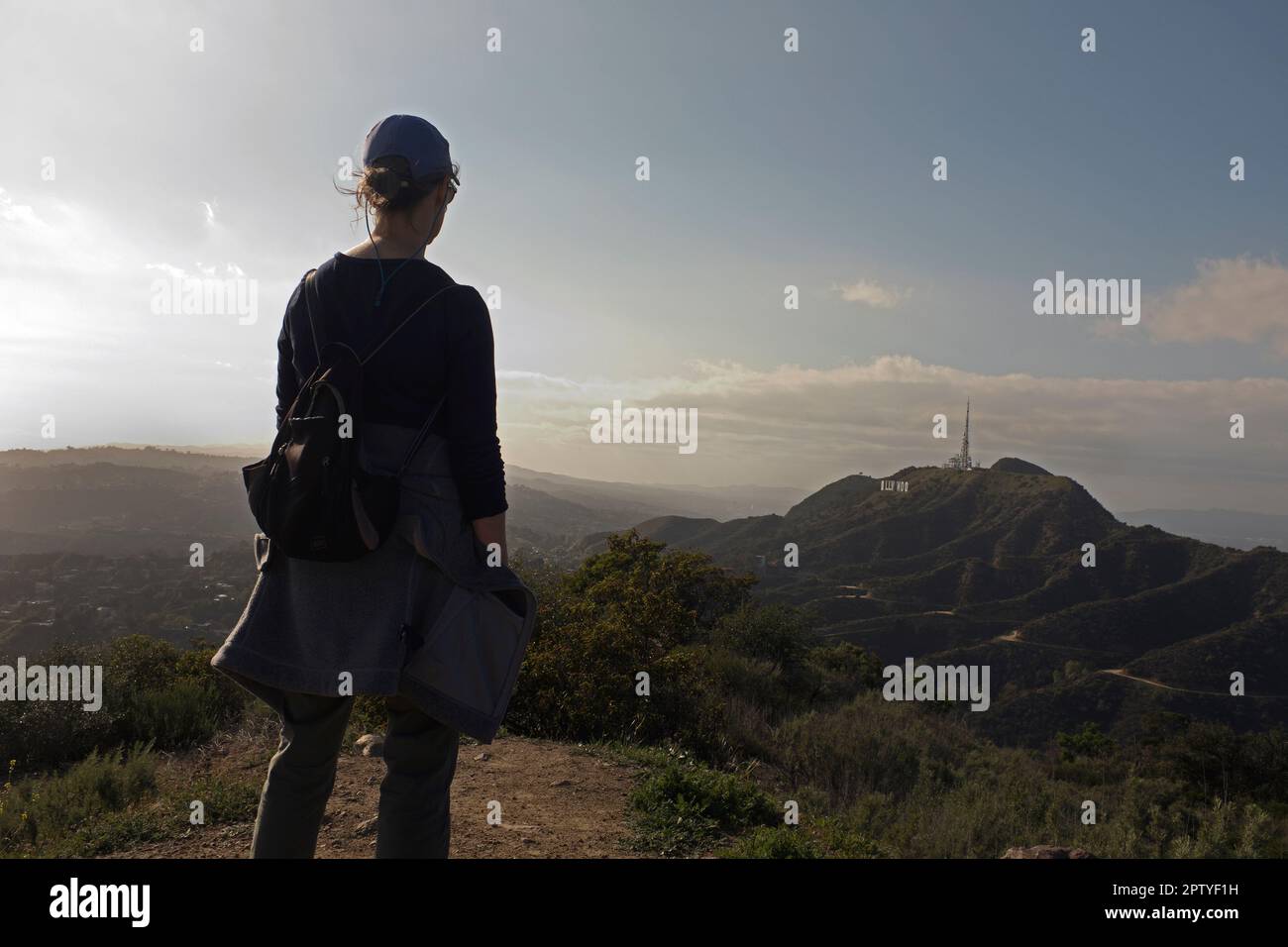 Vista posteriore di Hiker Viewing Hollywood Sign e Santa Monica Mountains in The Distance, Los Angeles, California, USA Foto Stock