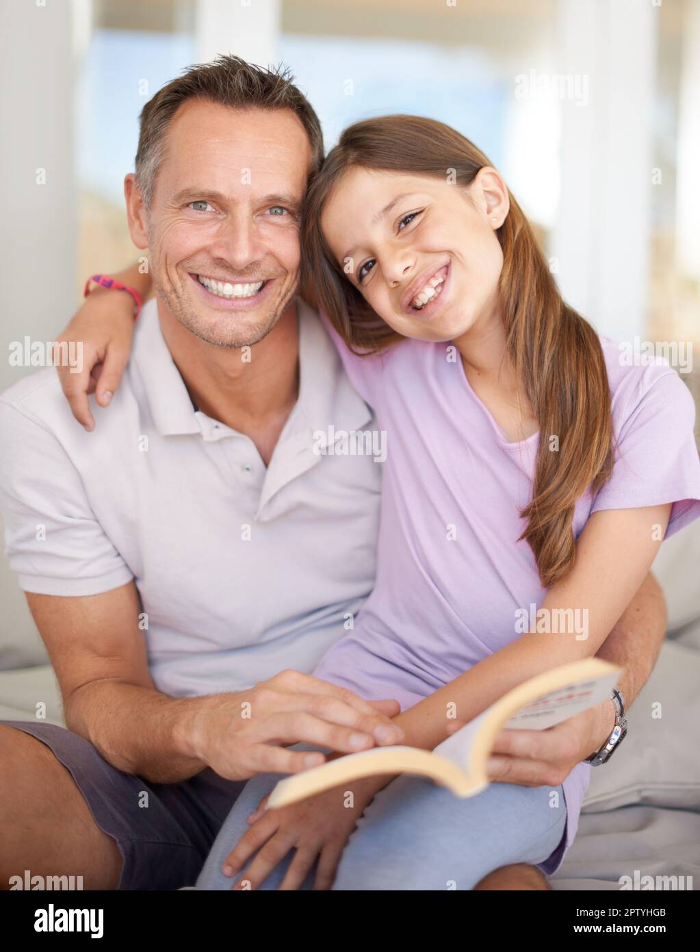 La lettura è per la gente impressionante. Ritratto di un padre e di una figlia che leggono un libro insieme Foto Stock