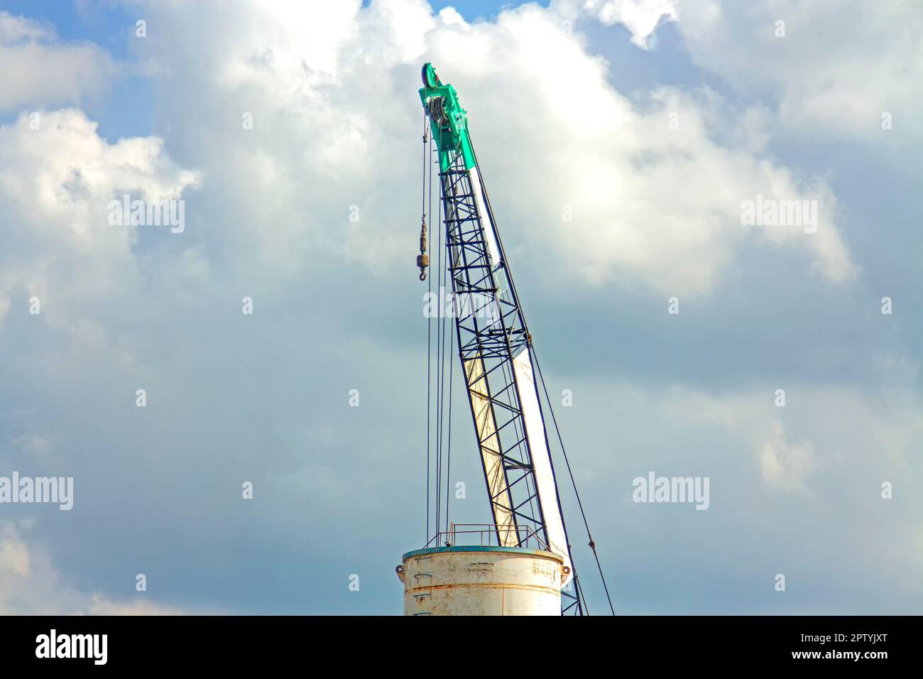 Gru ascensore verde funzionante nel cielo blu backgound Foto Stock